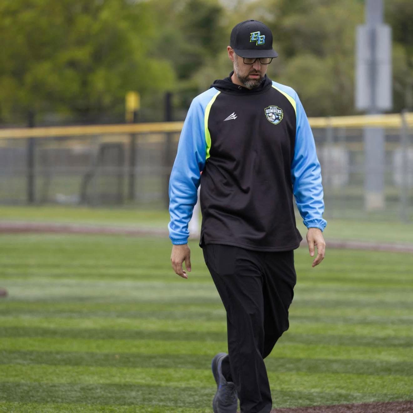 Coach Kyle Richardson walking on the baseball field